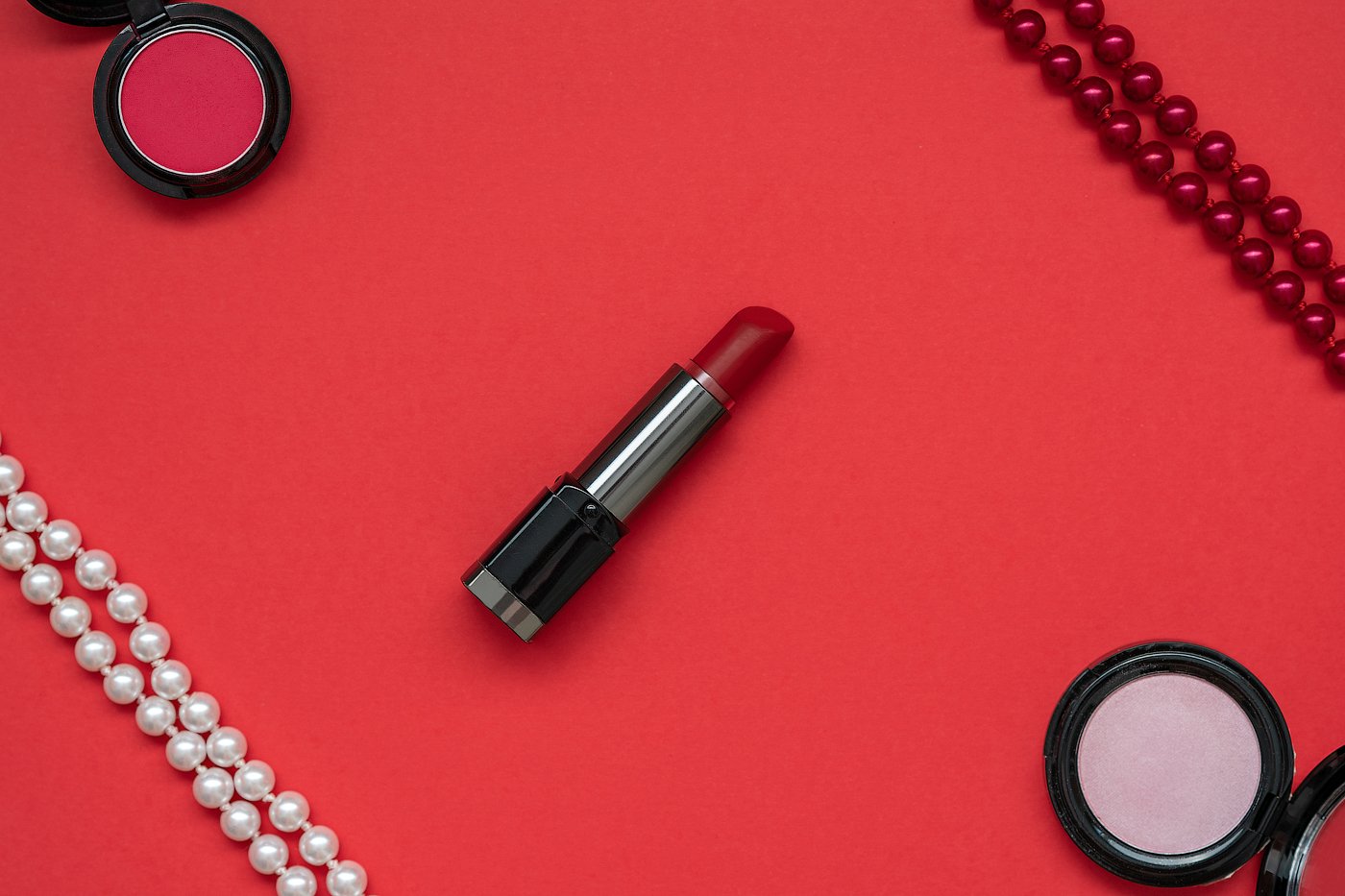 Red lipstick, white and red beads, red and pink eye shadows (673628