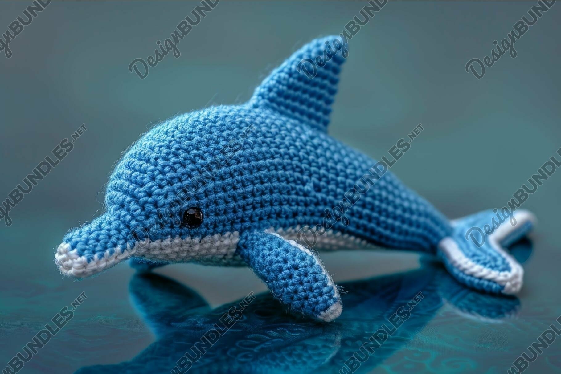 Handmade crochet dolphin toy on blue background