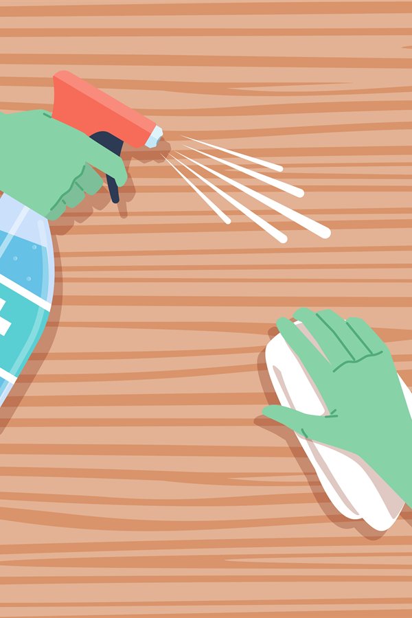 Surface disinfection. Cleaning wooden table, hands in protec