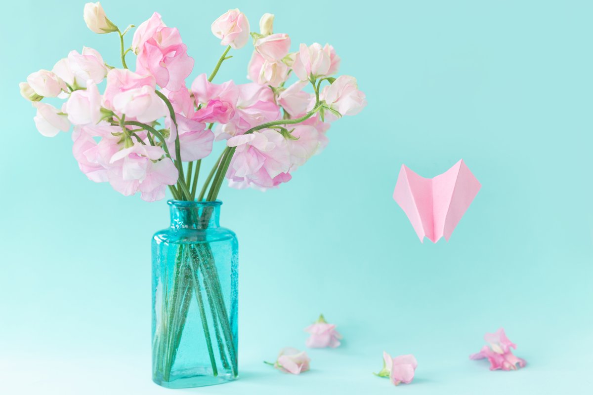 Pink sweet peas Lathyrus flowers in blue vase.Paper airplane example image 1