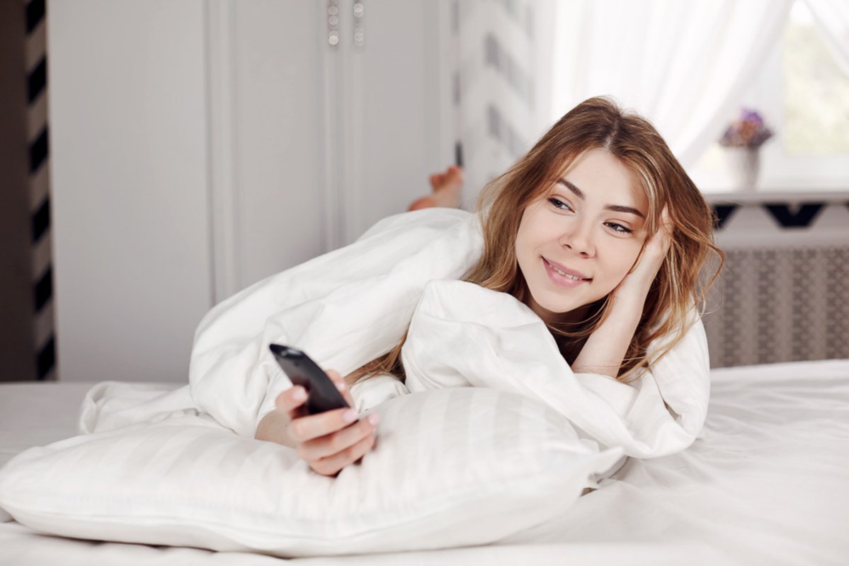 Young girl covered with a blanket is lying on the bed example image 1