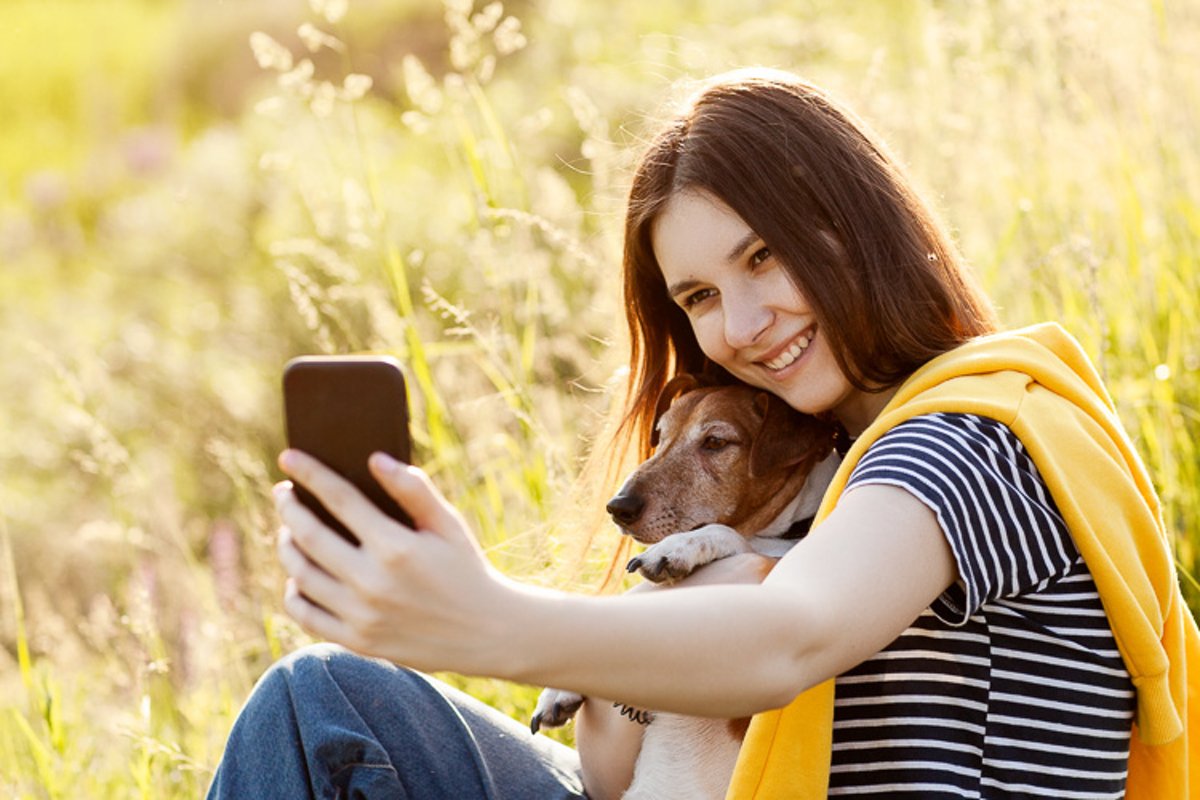 Girl sitting on grass and hugs dog Jack Russell Terrier example image 1