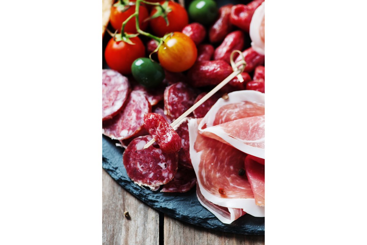 Antipasto with ham, olive and tomato on the wooden table example image 1