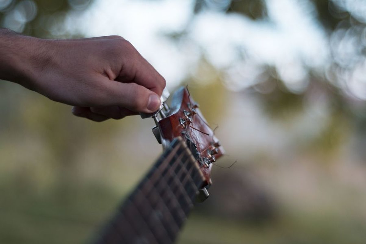 Man plays on acoustic guitar in a park example image 1