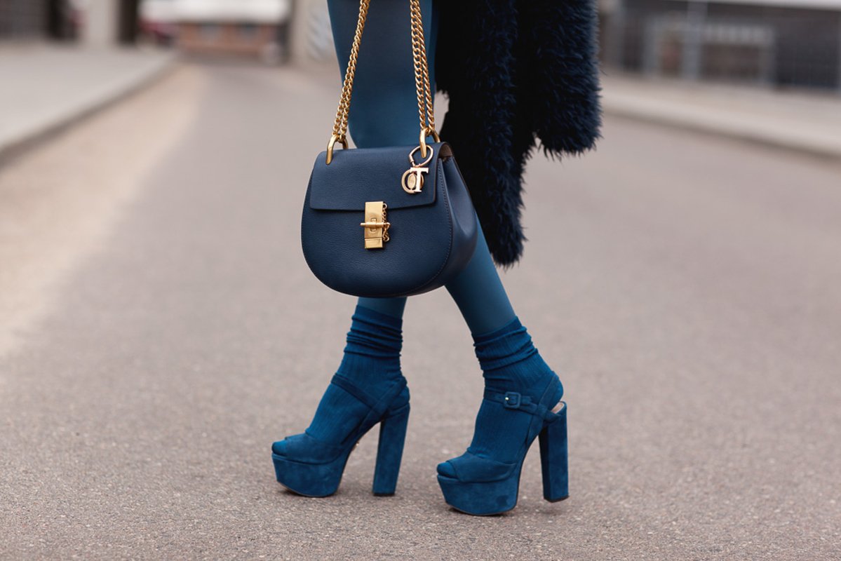 Stylish girl in a blue fur coat with a handbag in high heels example image 1