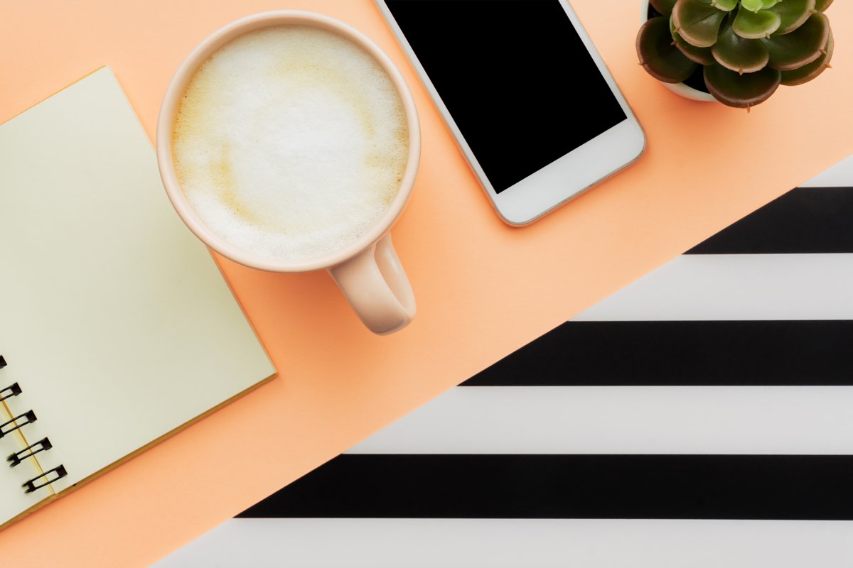 desk workspace with smartphone, blank notepad, pen, cup of c example image 1