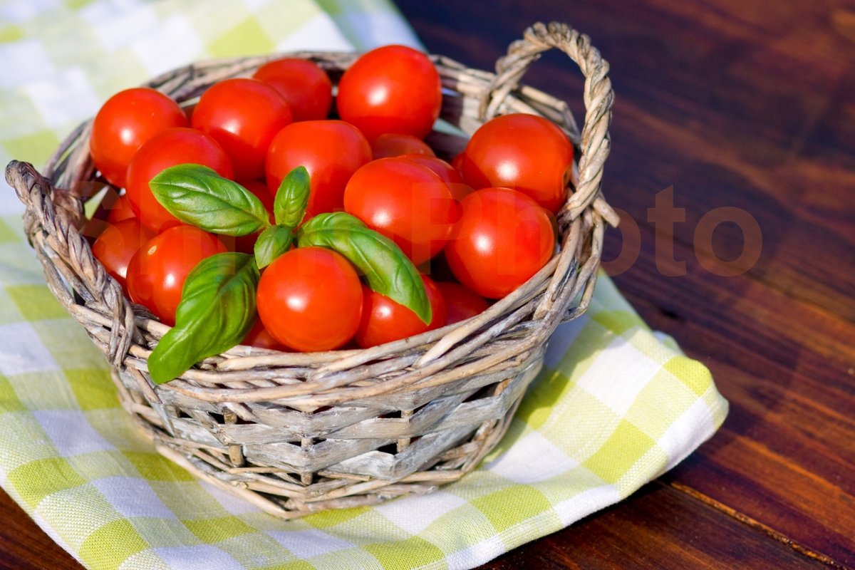 Tomatoes with basil in basket outdoors example image 1