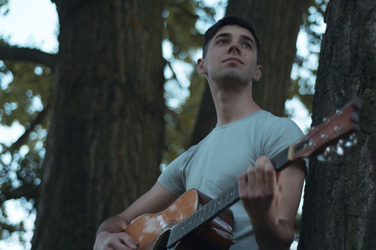 Man plays on acoustic guitar in park example image 1