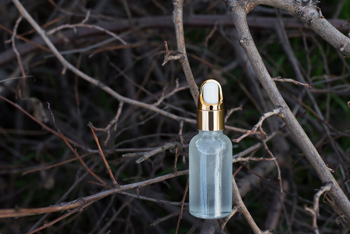 Natural essential cosmetic oil in background with tree branc example image 1