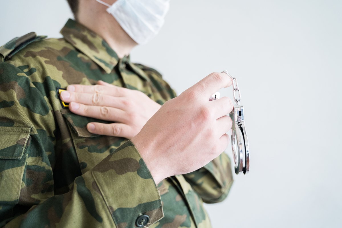 Officer with handcuffs. Face mask. Isolation violation fine example image 1