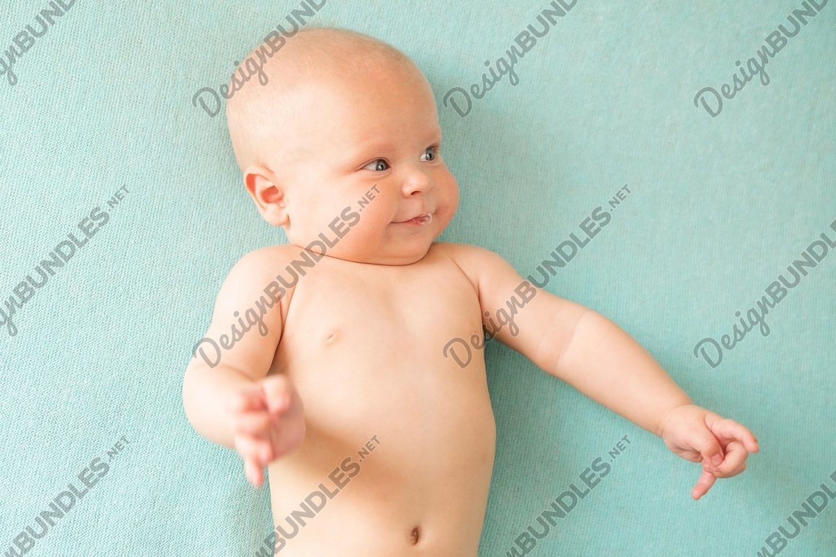 Baby boy lies on light green background and drooling example image 1