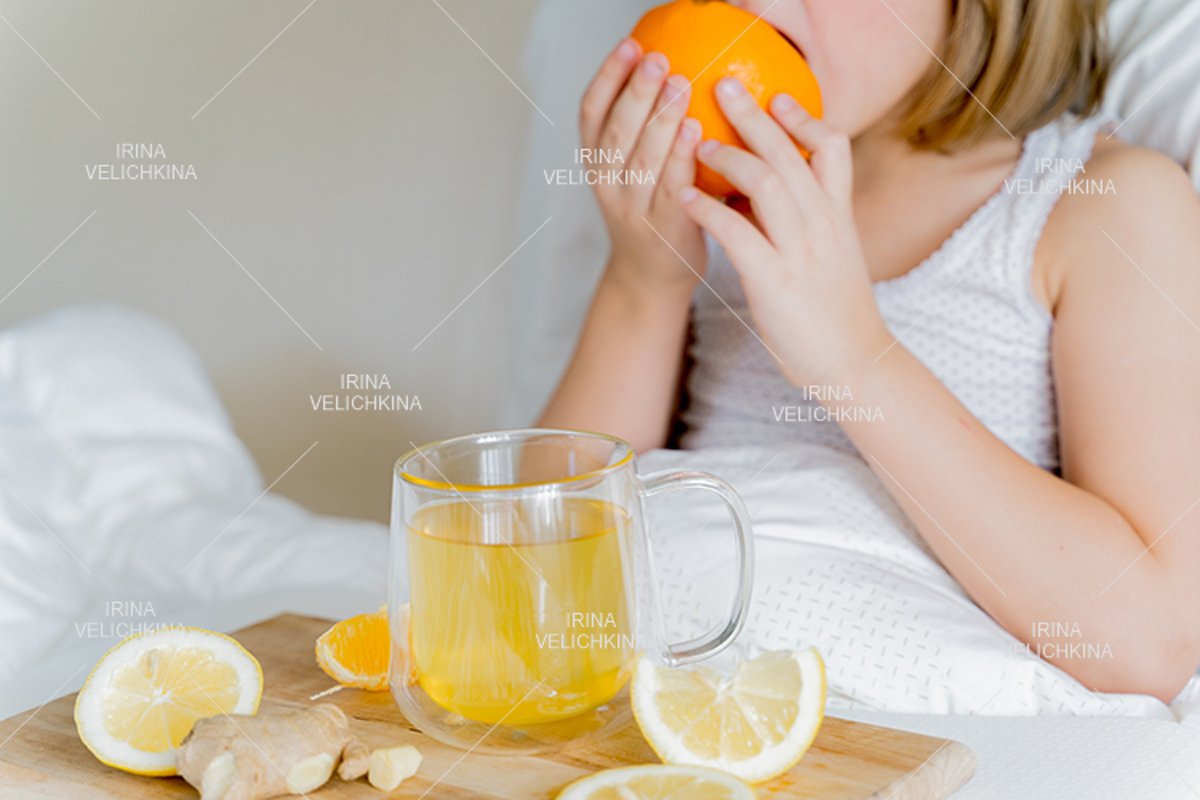 Sick girl in bed. Cup of flu drugs. Tea, orange,lemon,ginger example image 1