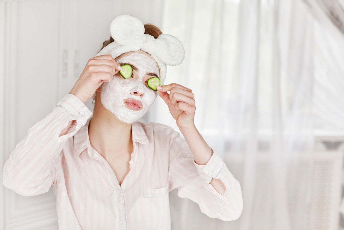 Girl with a face mask and slices of cucumber example image 1