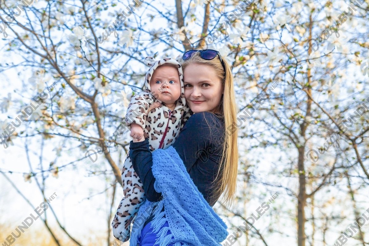 Photo of a mother with a baby on flowering trees background example image 1