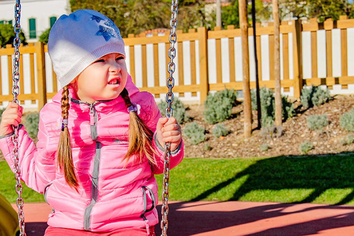 Little girl 5-6 years on a playground swinging on swing. example image 1