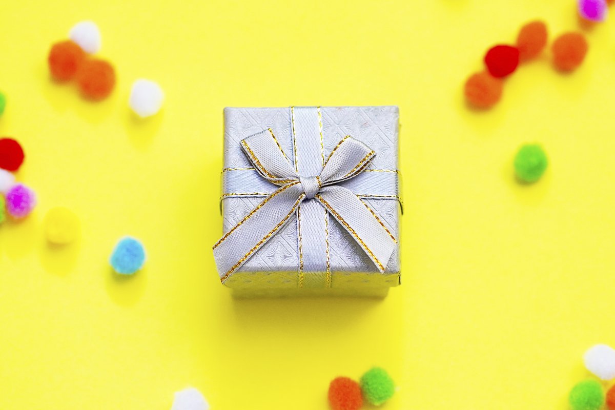 Gift box with multi-colored confetti on a yellow background example image 1