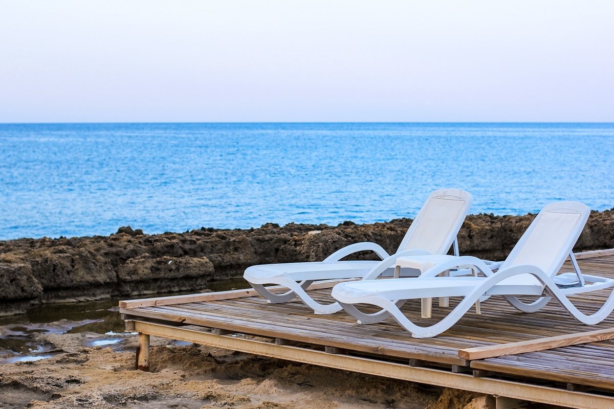 Tropical beach view with white empty chairs example image 1
