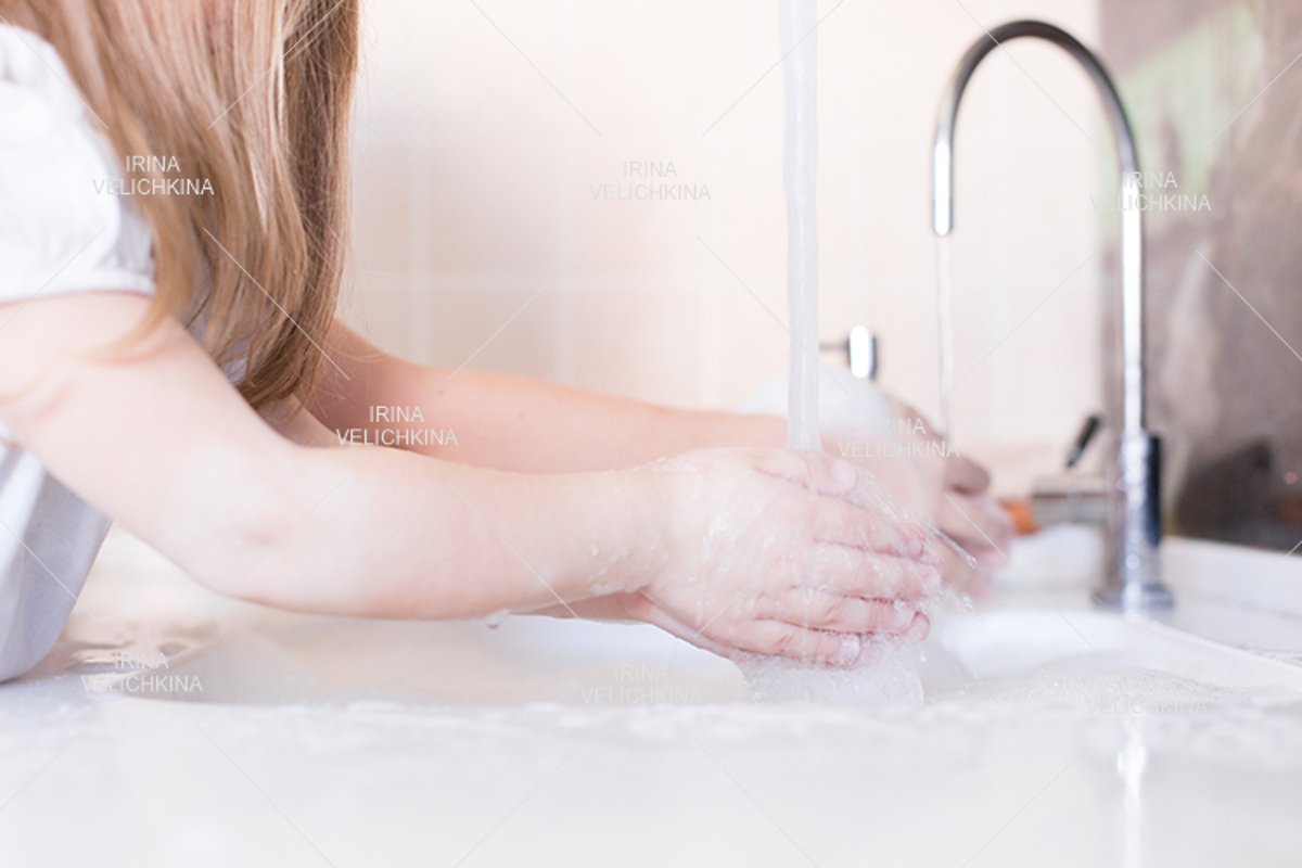Girls wash their hands in the sink with soap in the foam example image 1