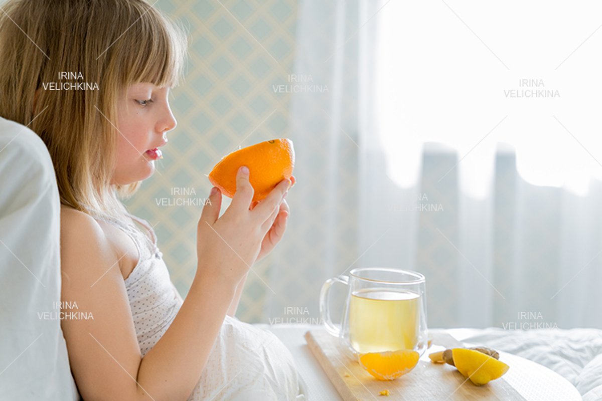 Sick girl in bed. Cup of flu drugs. Tea, orange,lemon,ginger example image 1