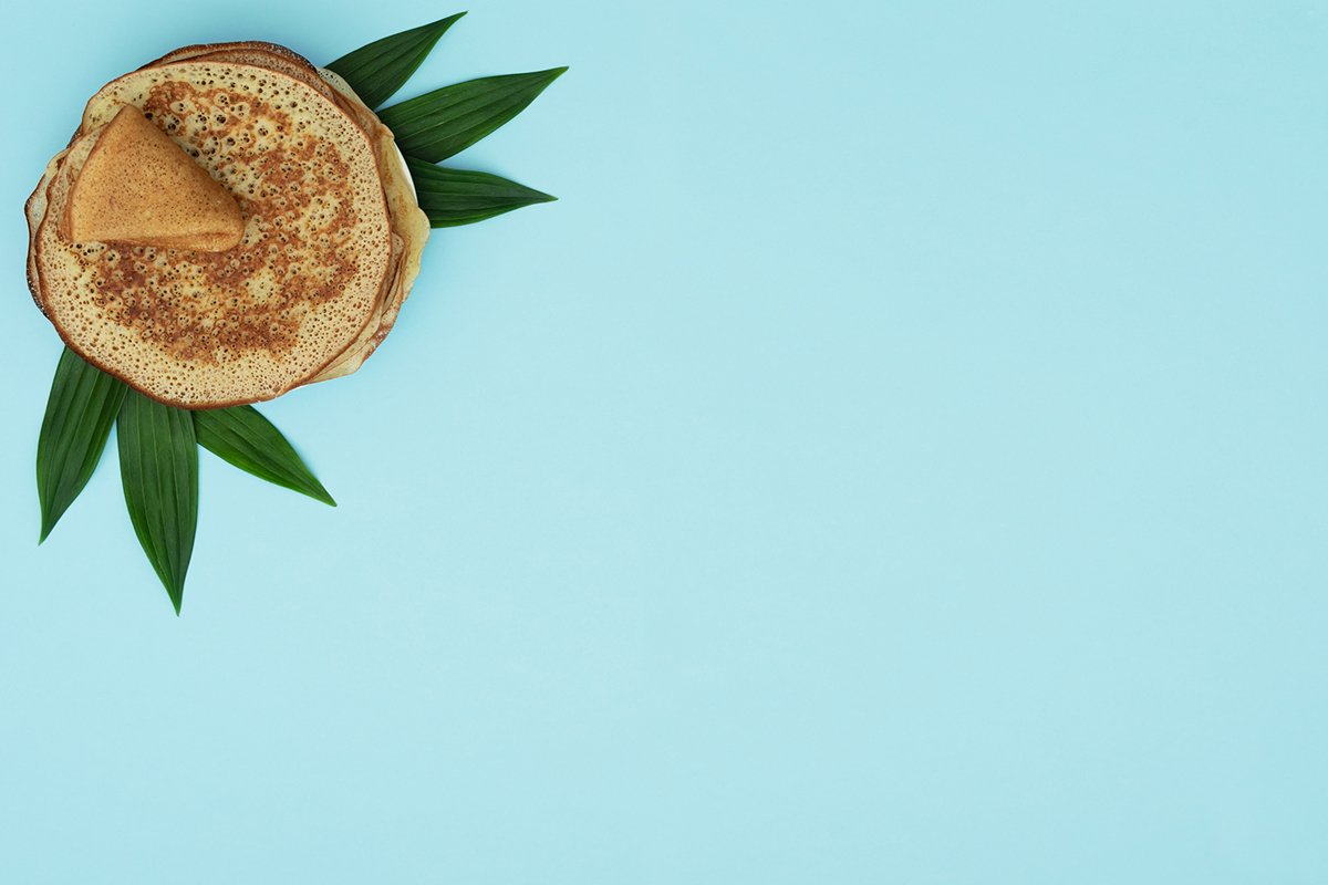 Homemade pancakes on blue background with green leaves example image 1