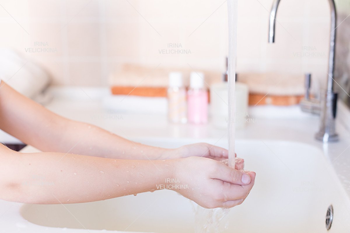 Girls wash their hands in the sink with soap in the foam example image 1