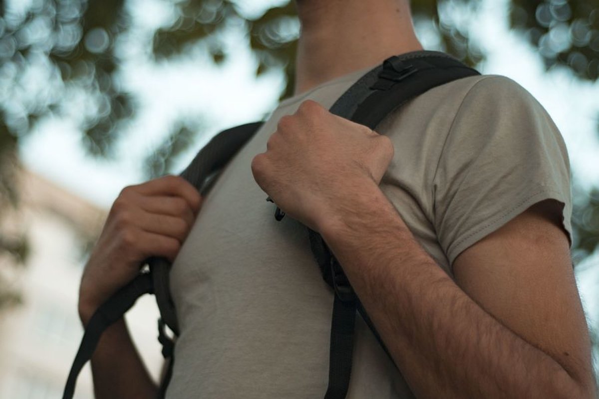 Young caucasian man walks in a park with backpack example image 1