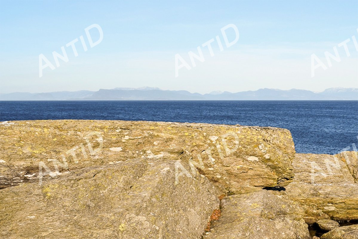 Stony shore, the sea, on the horizon of the mountain. example image 1