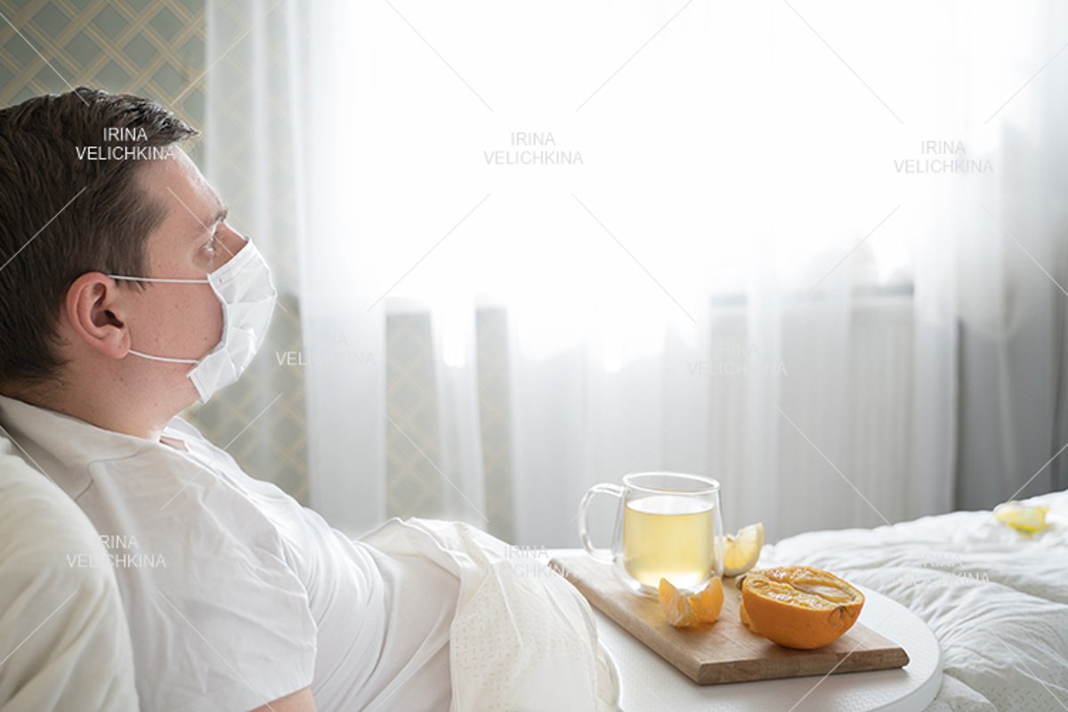 Sick man in bed. Face mask. Cup of tea, orange,lemon,ginger example image 1