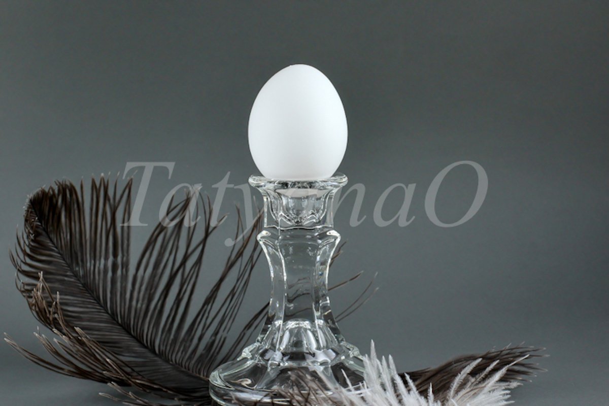 A white chicken egg in a vintage classic glass candlestick example image 1