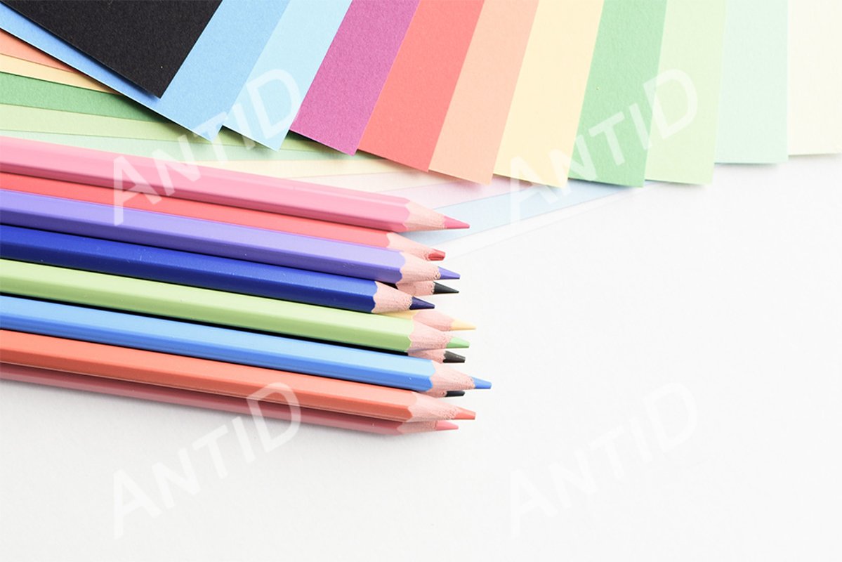 Colored pencils and colored paper on a white background example image 1
