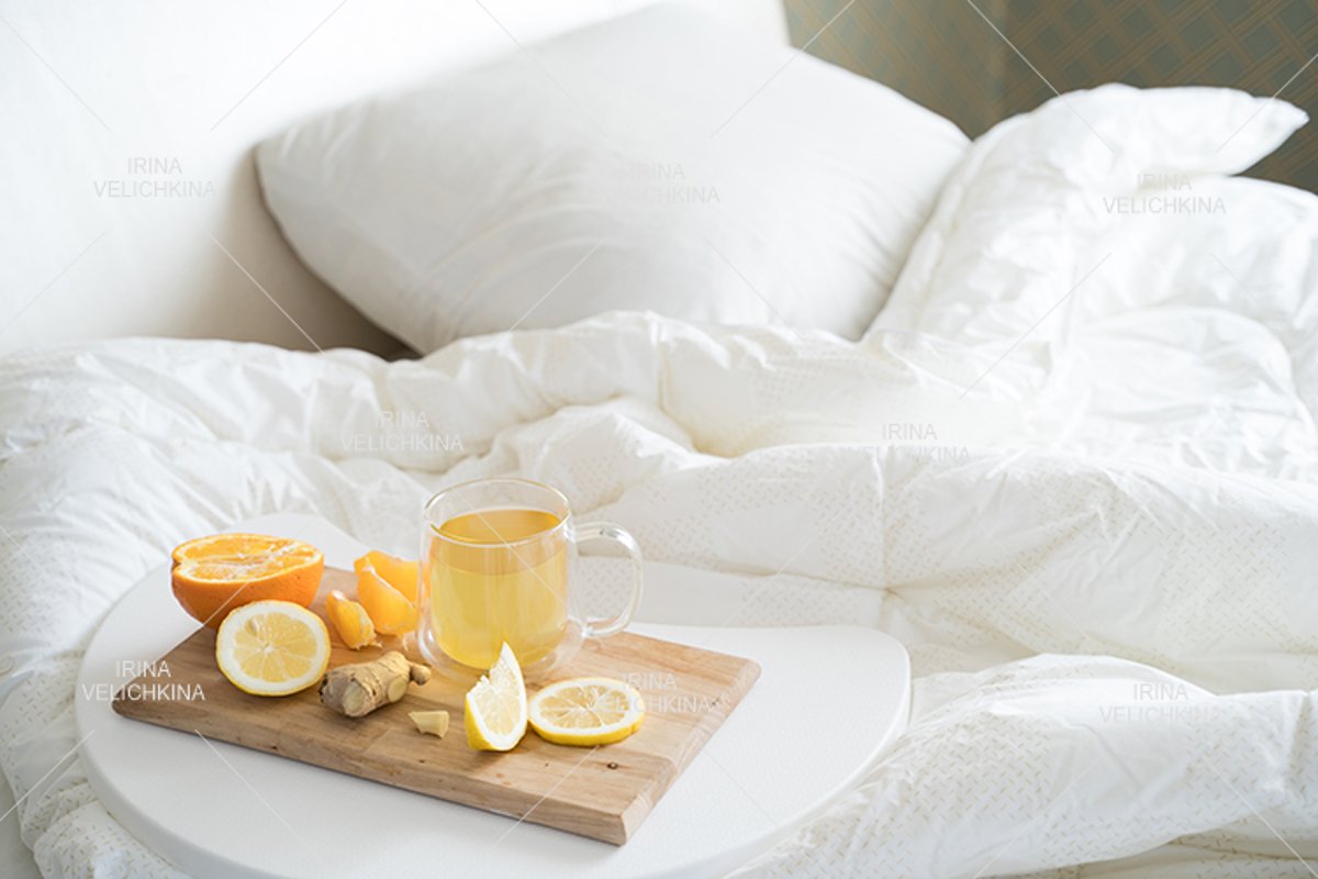 Cup of tea,orange,lemon,ginger in bed.Self treatment for flu example image 1