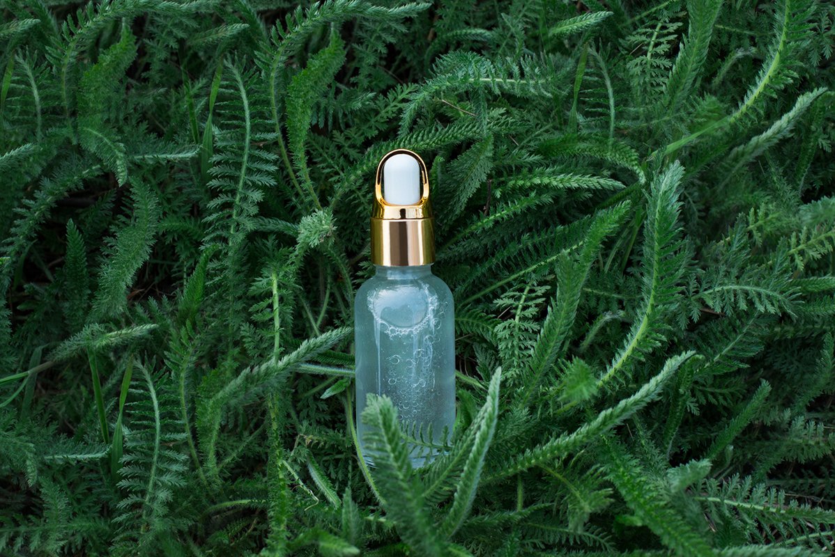 Natural herbal cosmetic oil in background with green grass. example image 1