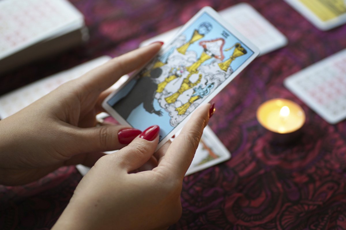 Tarot cards on table near burning candles example image 1