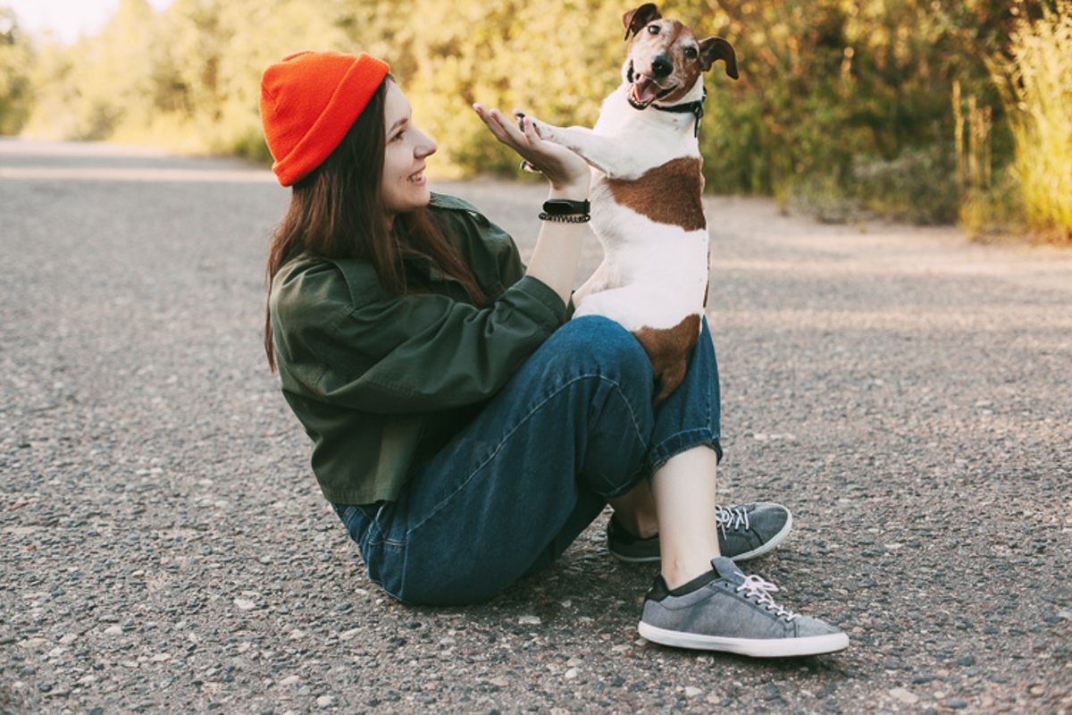 A pretty brunette holds her dog in her arms and smiles. example image 1