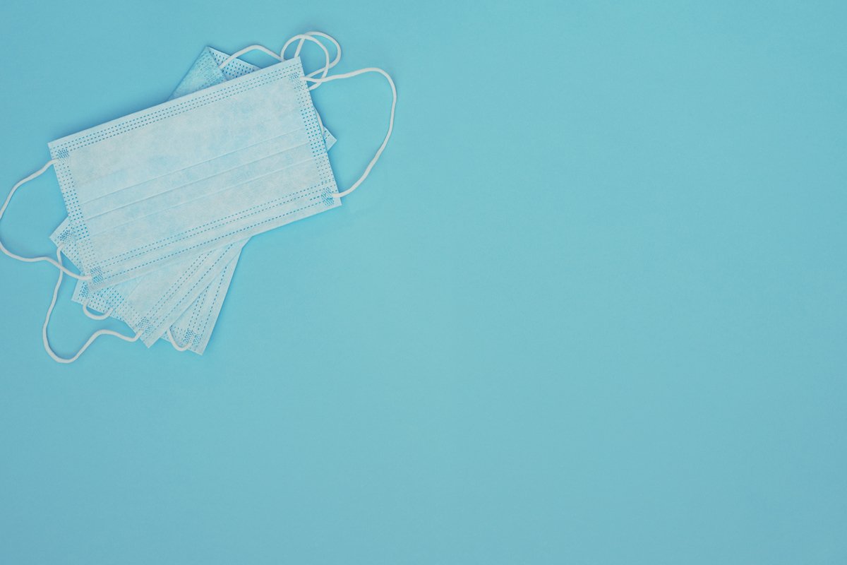 Light blue medical masks on blue background. example image 1