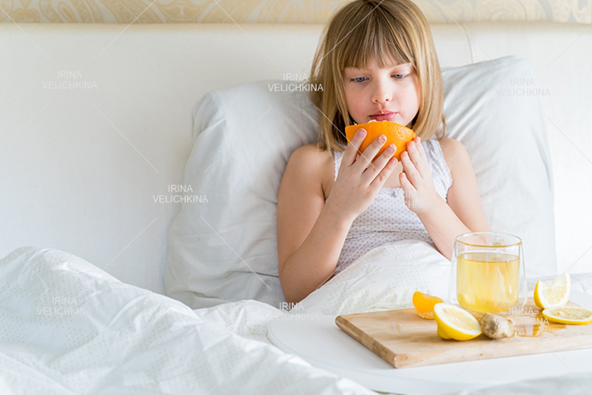 Sick girl in bed. Cup of flu drugs. Tea, orange,lemon,ginger example image 1