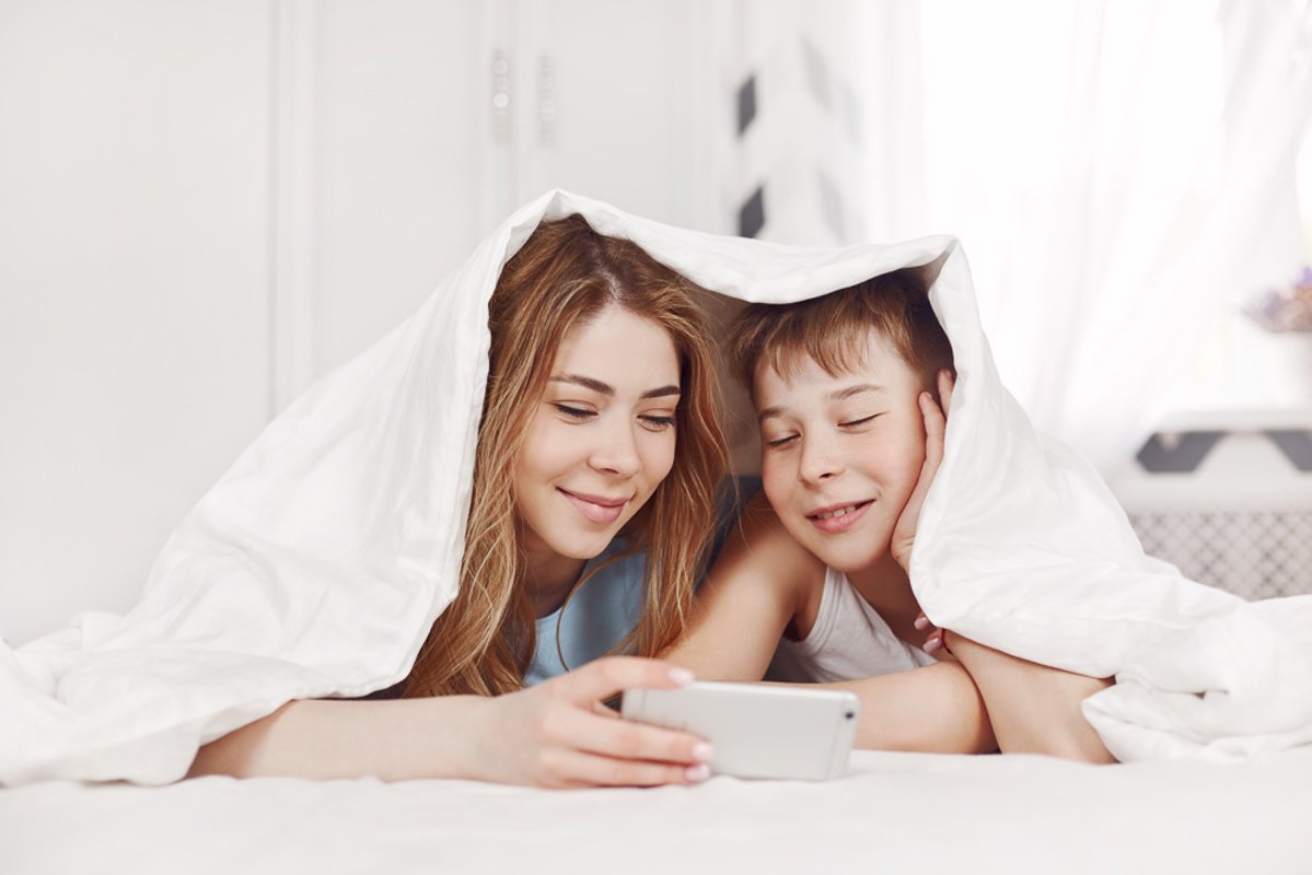 The girl and her younger brother look at photos on the phone example image 1