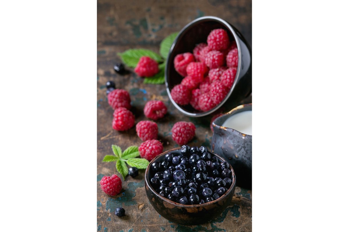 Bowls of raspberries and blueberries example image 1