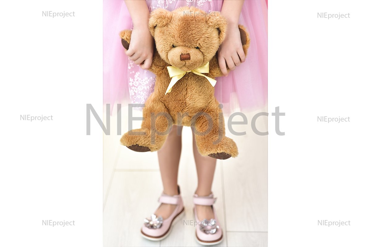 Child in pink dress with teddy bear. Close up example image 1