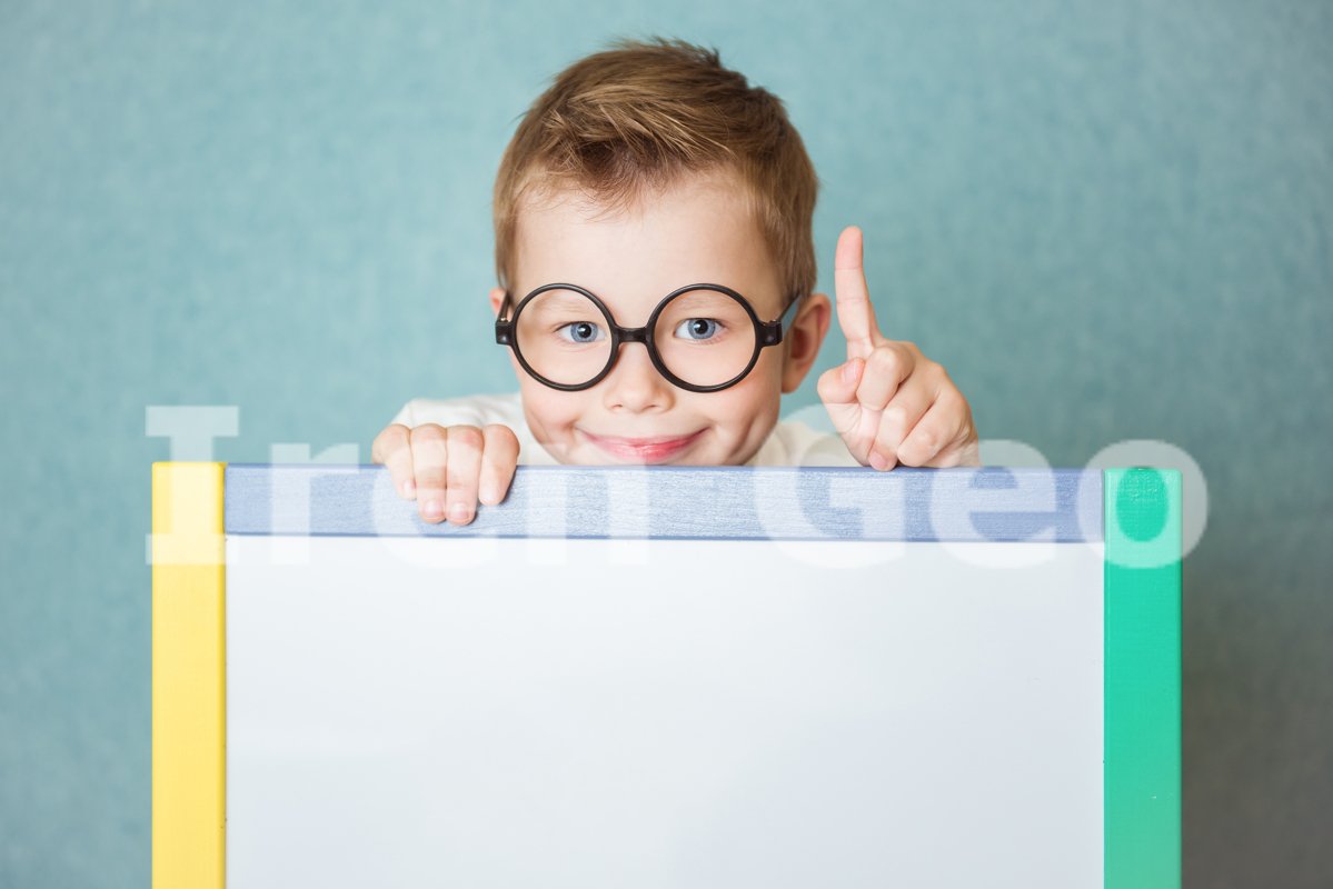 Young boy holding white blank board on blue background example image 1