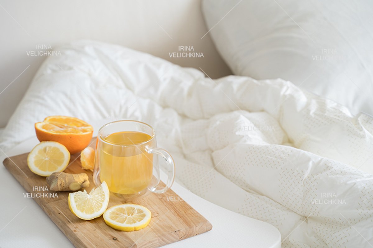 Cup of tea,orange,lemon,ginger in bed.Self treatment for flu example image 1