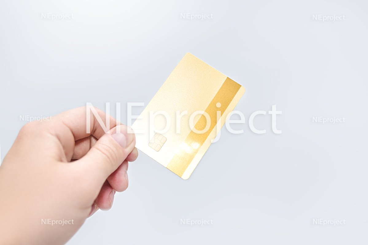 Man holding gold credit card in hand on white background example image 1