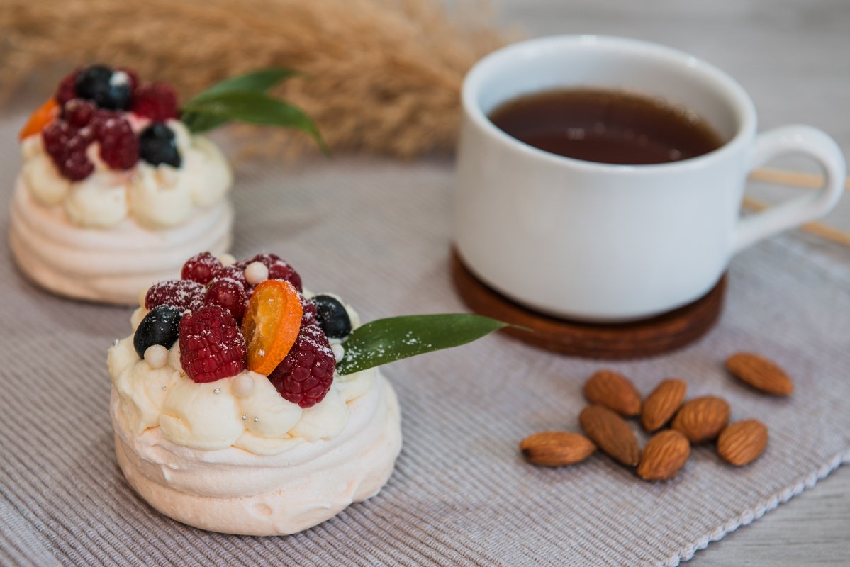 Pavlova meringue desert cake with cream and small fruits example image 1
