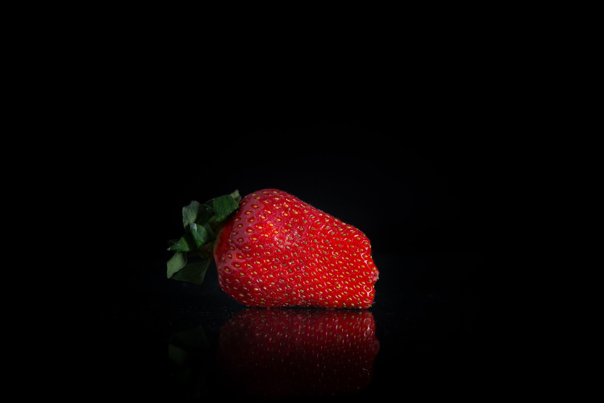 Giant fresh strawberries on a black background example image 1