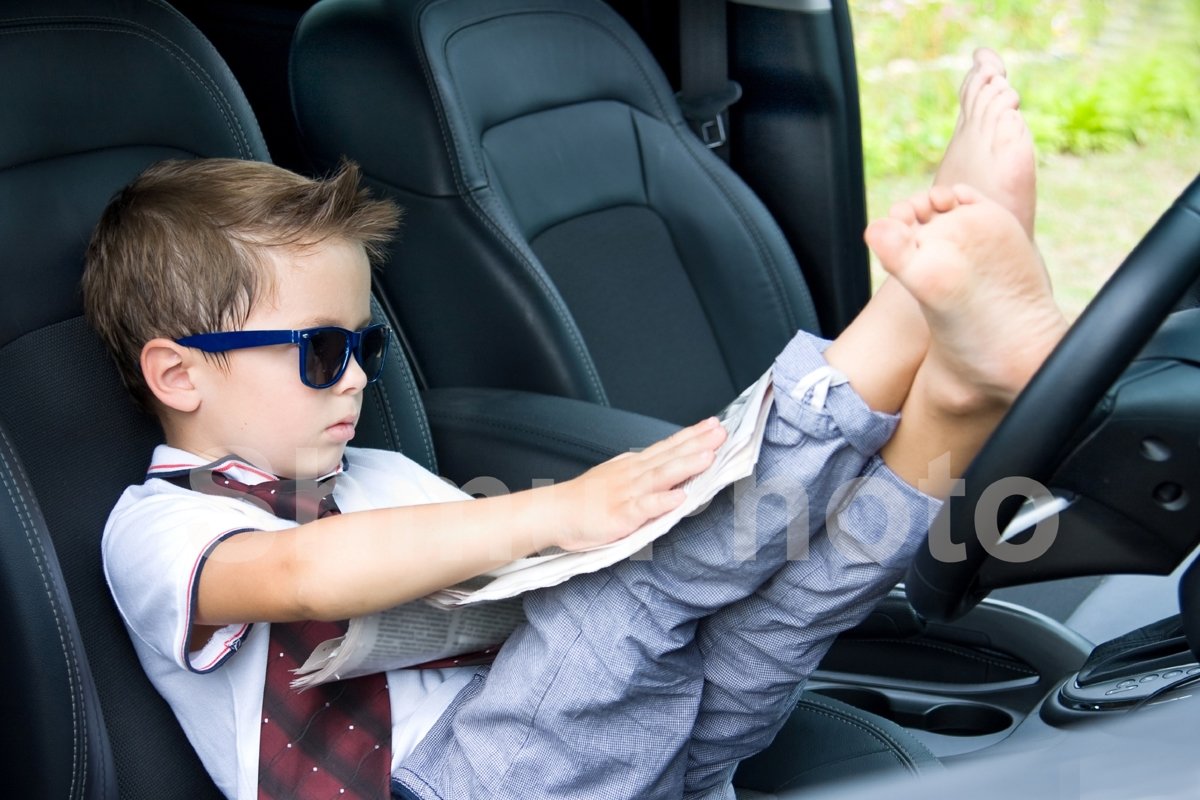Cute driver. Smilng boy in sunglases in car example image 1