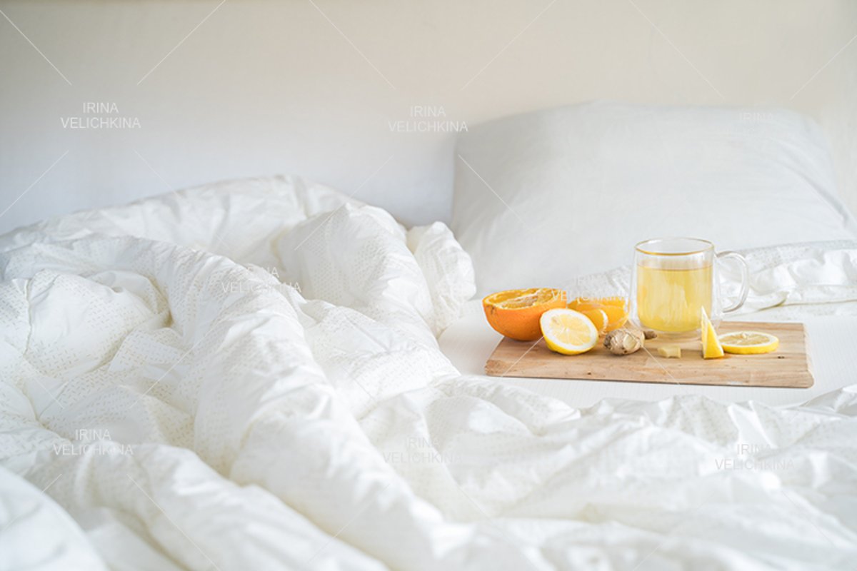 Cup of tea,orange,lemon,ginger in bed.Self treatment for flu example image 1