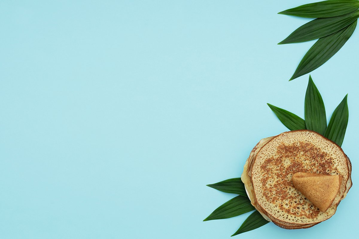 Homemade pancakes on blue background with green leaves example image 1