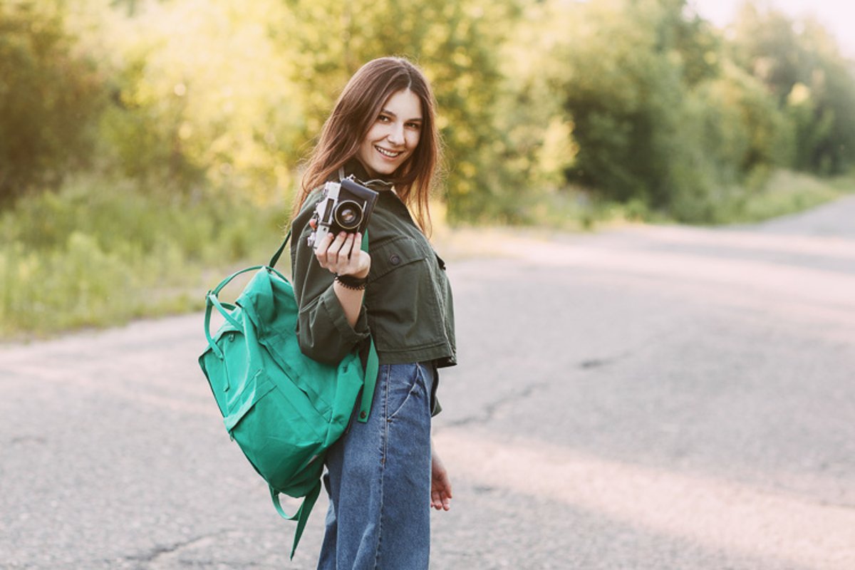 A girl with a camera in her hands is on the road example image 1