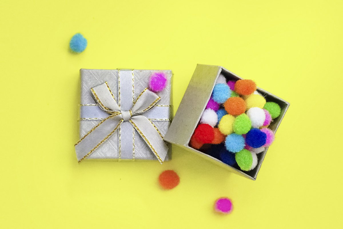 Gift box with multi-colored confetti on a yellow background example image 1