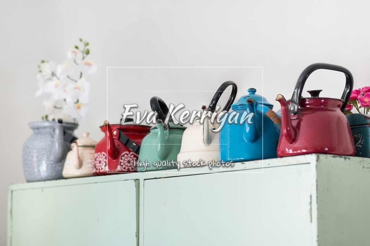 Old metal multi-colored teapots stand on a wooden cabinet. example image 1